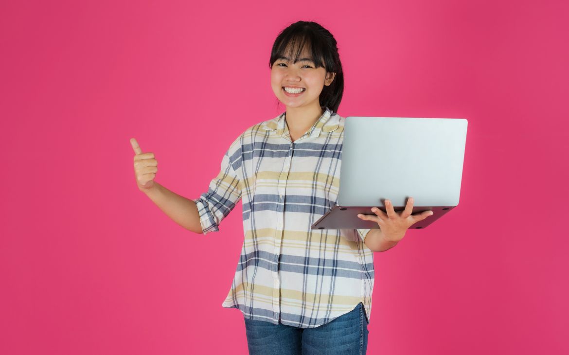 Girl with laptop on a pink background